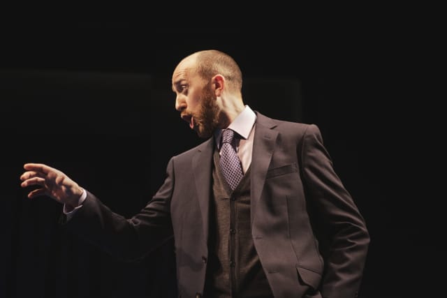 Adam points towards something off-stage in the National Theatre's My Country